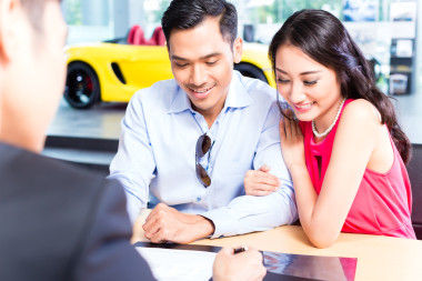 對(duì)夫婦簽署汽車經(jīng)銷商處的銷售合
