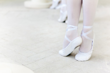 三个小芭蕾舞演员在跳舞脚在芭蕾舞平底鞋特写