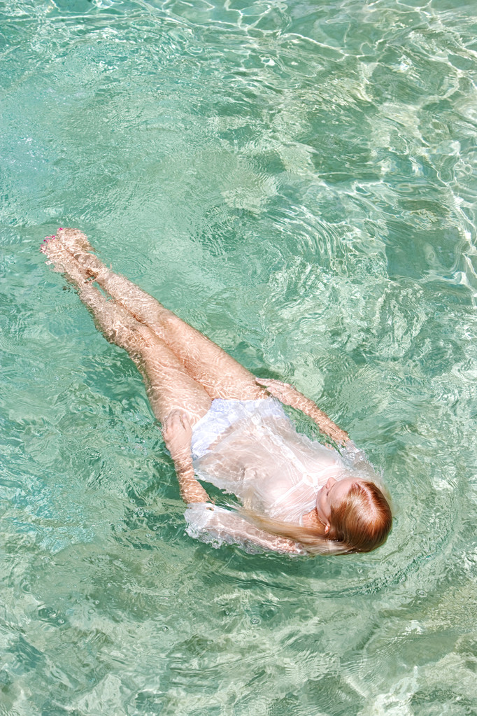 年轻女子在游泳池中游泳 年轻女子在游泳池中游泳