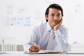 在他的记事本中绘图的商人图片