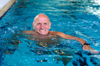 活躍的老人在游泳池里游泳