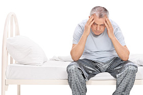 沮丧的老人坐在床上