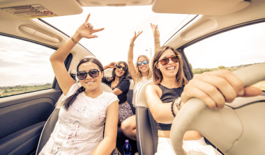 四個女孩在一輛敞篷車開車和樂趣