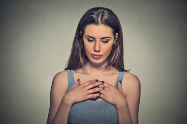 美丽的女人害羞紧张地玩着手向下看