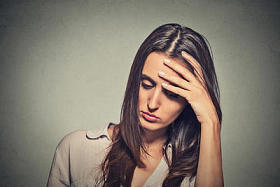肖像强调悲伤的年轻女子向下看