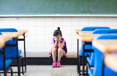 強(qiáng)調(diào)坐在女孩與思考教室地板圖片