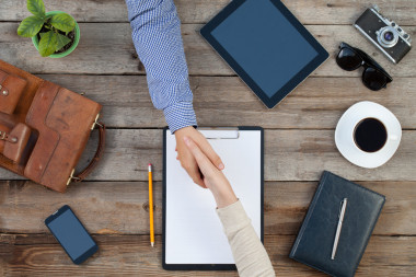 兩個商人在一張桌子在室內(nèi)握手