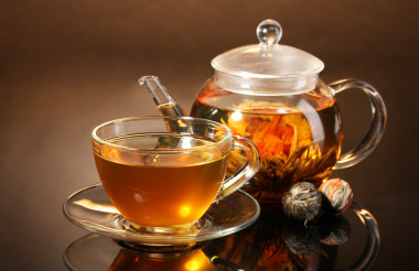 玻璃茶壺和異國(guó)情調(diào)綠茶棕色 backgro 上的木桌上的杯子