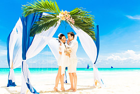 婚礼仪式在蓝色的热带海滩上。幸福的新郎和 br