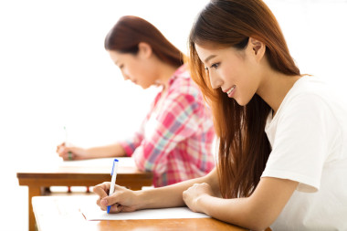 與其他年輕的學(xué)生在教室里寫作筆記