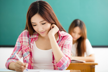 與其他年輕的學(xué)生在教室里寫作筆記