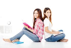 两个快乐的青少年学生女孩一起学习