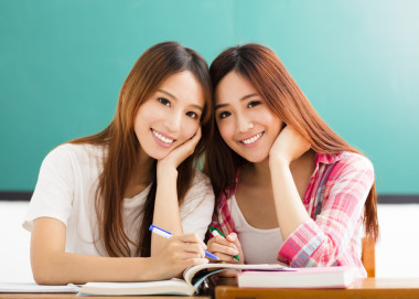 兩個快樂的青少年學(xué)生女孩在教室
