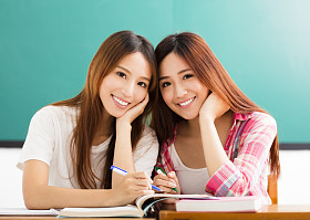 两个快乐的青少年学生女孩在教室