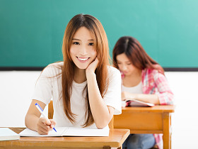 微笑的青年学生，与其他人在教室