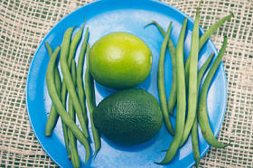 石灰、 鳄梨和绿色豆蓝板与乡村背景