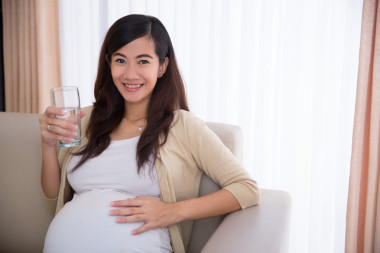 亞洲孕婦喝一杯水