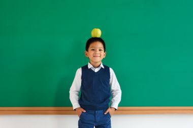 十幾歲的男生在口袋里抱著雙臂同時平衡在他頭上的蘋果