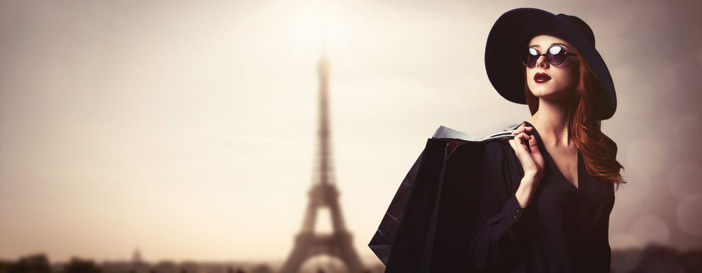 风格红头发的女人,太阳镜和购物袋 风格红头发的女人,太阳镜和购物袋