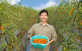在他的农场举行番茄中间岁快乐亚洲农夫