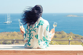 美少妇与葡萄酒面向大海的玻璃