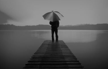 男子手持一把雨傘在湖概念照片