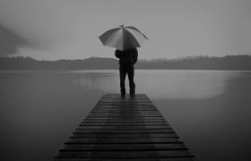 男子手持一把雨伞在湖概念照片