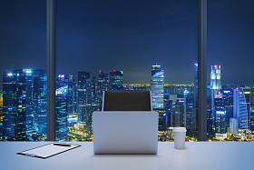 一个工作场所在一个现代的全景办公室与纽约的夜景一张白色的桌子一把黑色的皮椅子笔记本电脑,写作