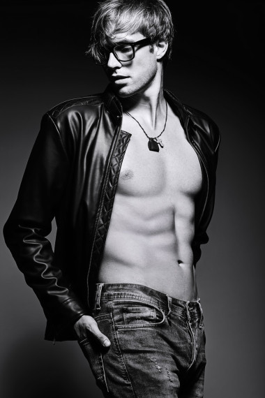 年轻英俊肌肉健美的男模特在摄影棚展示他的腹