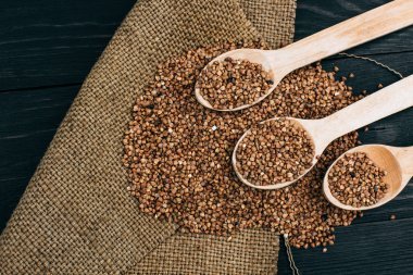 蕎麥去殼和木勺在黑色的桌子上