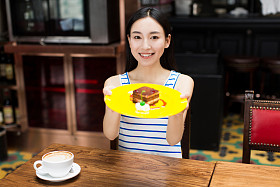 年轻美丽的女人在吃甜点