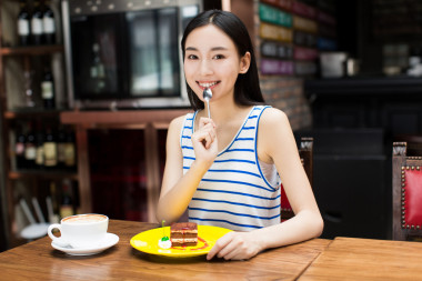年輕美麗的女人在吃甜點(diǎn)