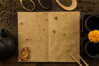 黑茶壺, 兩杯, 茶收藏, 鮮花, 木制背景上的舊空白打開書。菜單, 食譜, 模擬