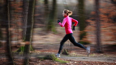 上一個(gè)寒冷的秋天在一個(gè)城市公園戶外運(yùn)行的年輕女子