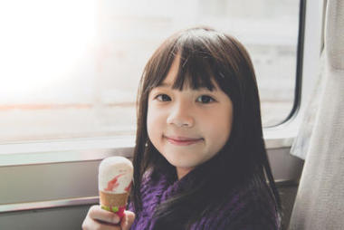 小小的亞洲女孩微笑著，吃冰激淋