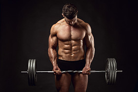 与大哑铃锻炼肌肉的健美运动员家伙