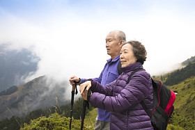 幸福的亚洲高级夫妇在山上徒步旅