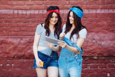 雙胞胎女孩看著平板電腦圖片