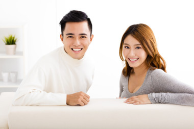 快樂的年輕夫婦，坐在沙發(fā)上圖片