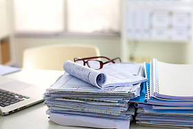 堆文件和眼镜躺在降低饱和度的表