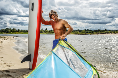 肌肉帥哥控股沖浪板.圖片