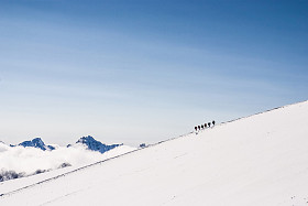 爬雪山顶上的登山者。梦线.图片