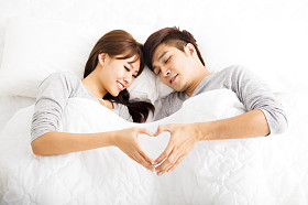躺在床上的快乐年轻可爱夫妇