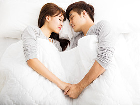 躺在床上的快乐年轻可爱夫妇图片