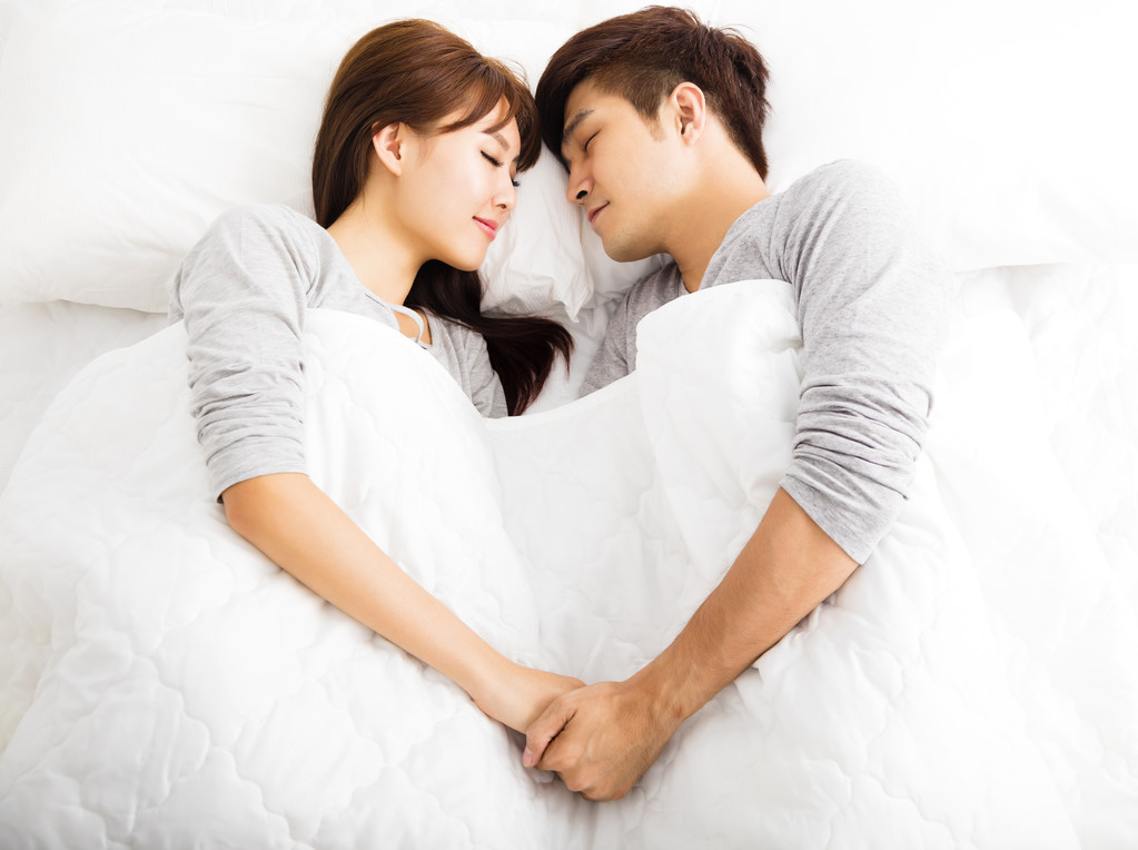 躺在床上的快乐年轻可爱夫妇图片