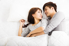 躺在床上的快乐年轻可爱夫妇