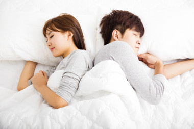 快樂(lè)年輕可愛(ài)夫婦睡在床上照片