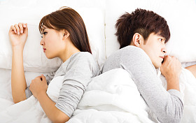 打乱年轻夫妇并排躺在床上图片