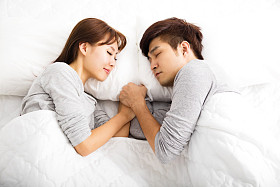 躺在床上的快乐年轻可爱夫妇照片
