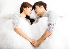 躺在床上的快乐年轻可爱夫妇